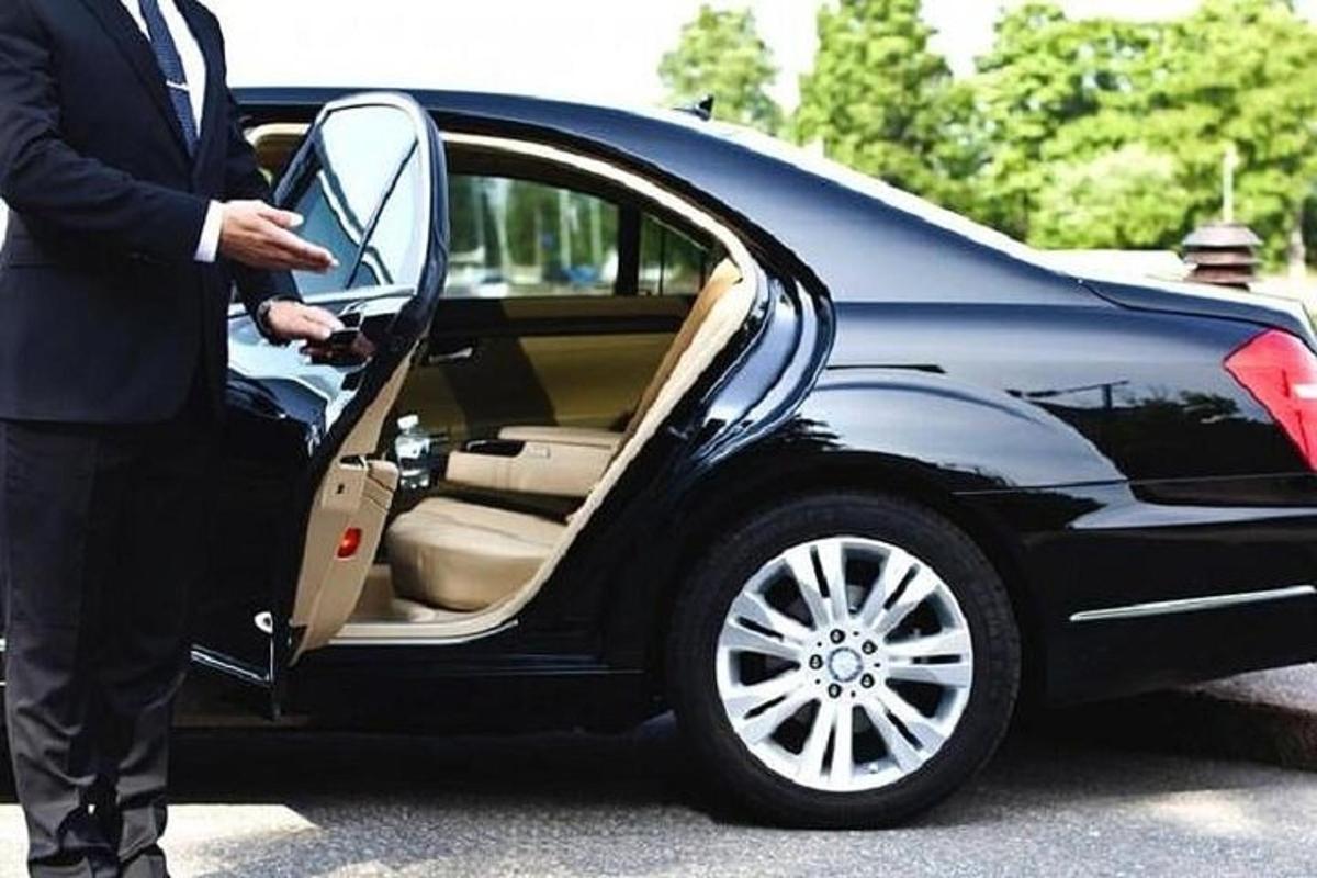 um homem abrindo a porta de um carro preto