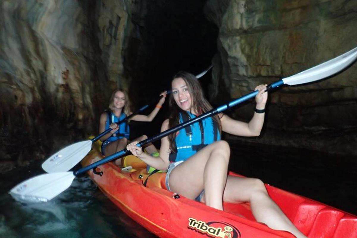 two women in a red kayak in a cave