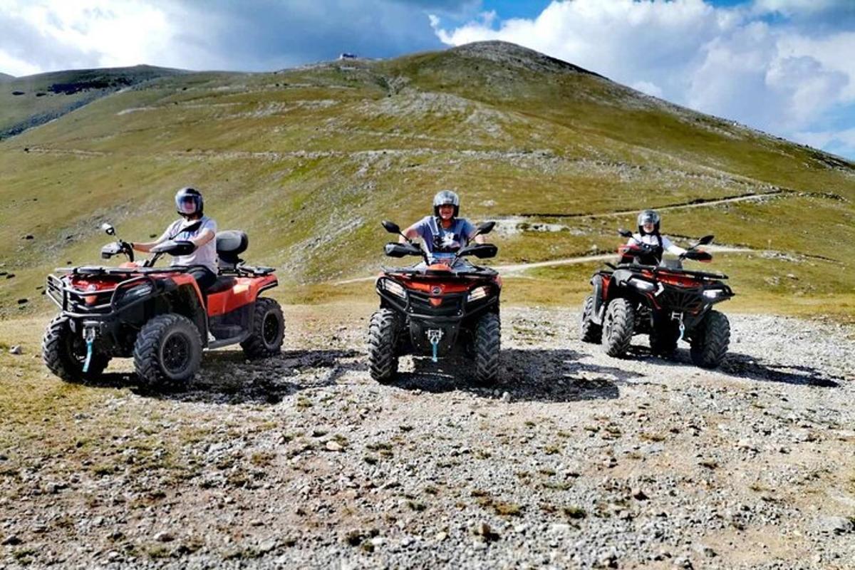three people riding atvs on a rocky hillside