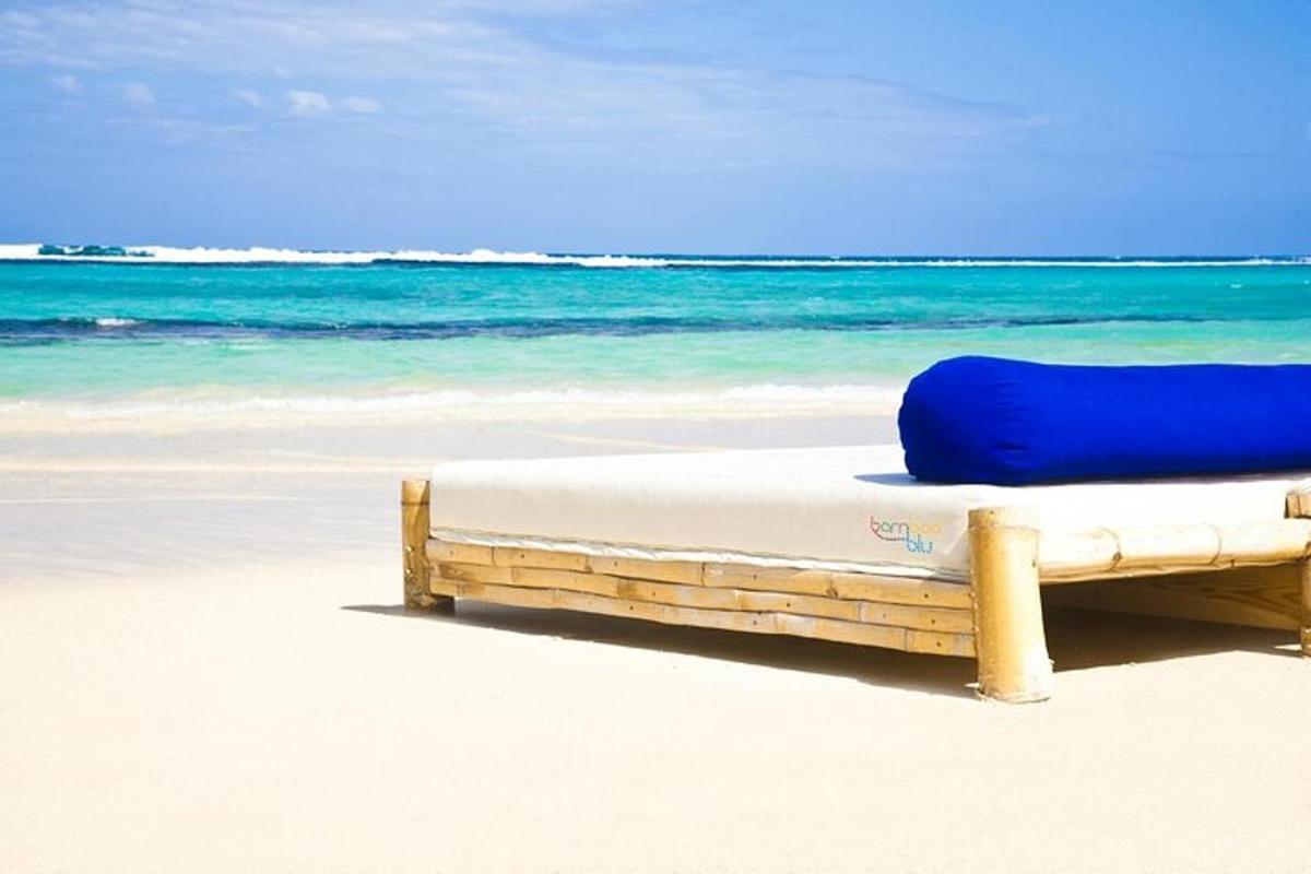 een bed op een strand met de oceaan op de achtergrond