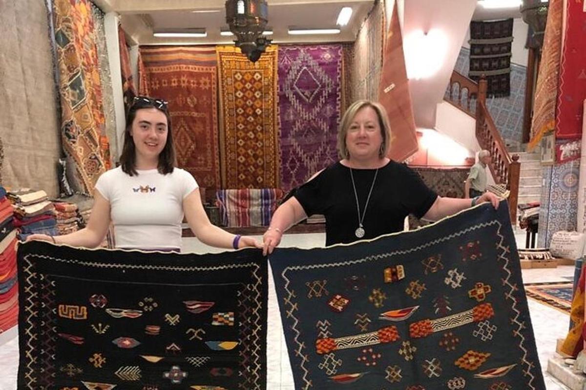 Dos mujeres sostienen almohadas en una tienda.