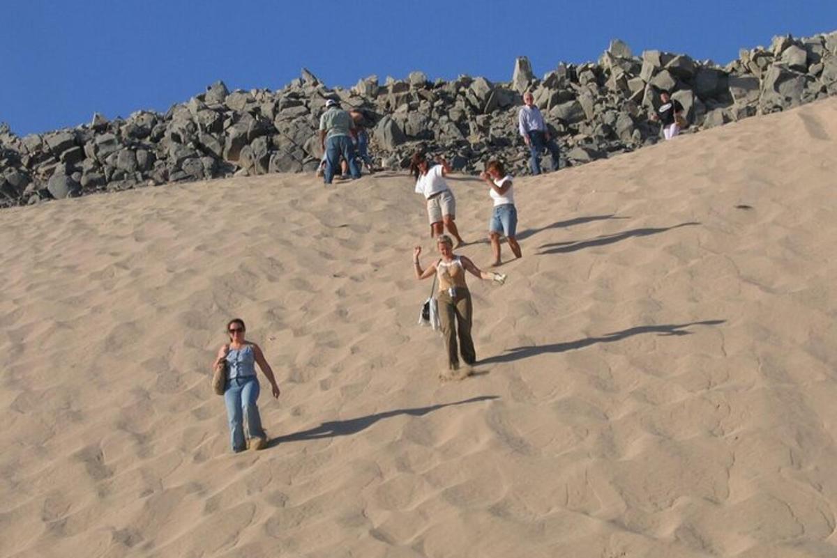 un gruppo di persone che cammina su una collina di sabbia