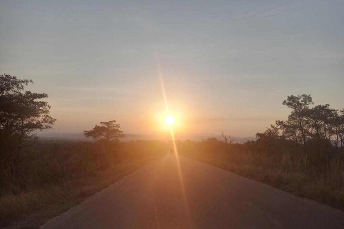 a road with the sun setting on the horizon