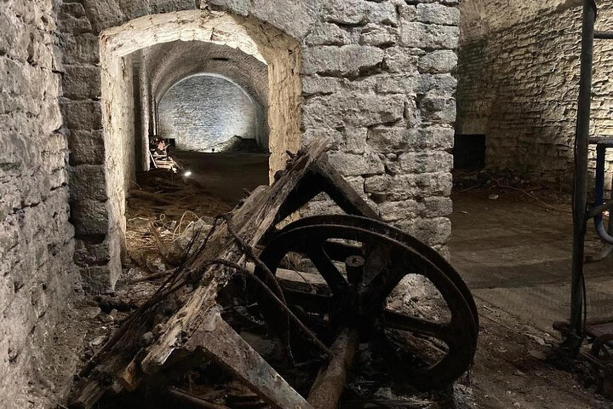a room with a stone fireplace with a wheel in it