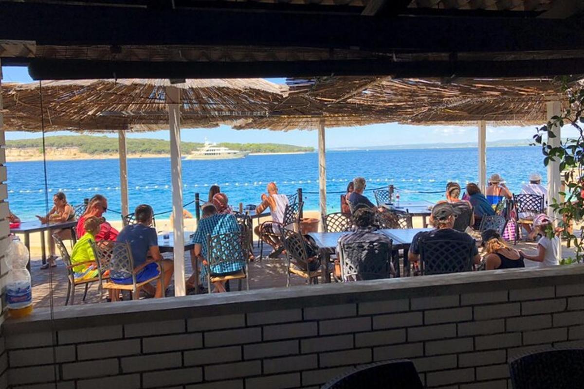 eine Gruppe von Menschen sitzt an einem Tisch am Strand