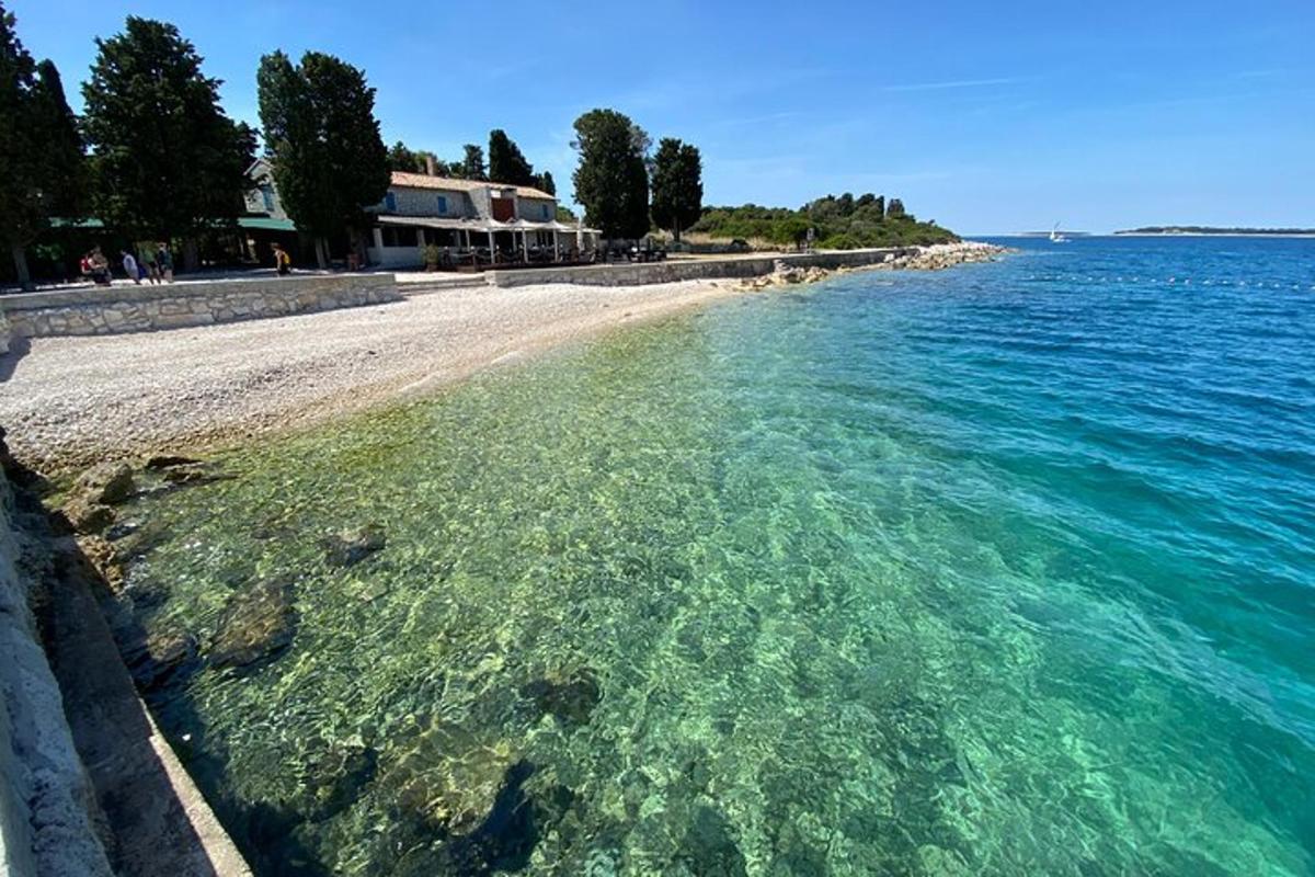 ein Strand mit türkisfarbenem Wasser und felsigem Ufer