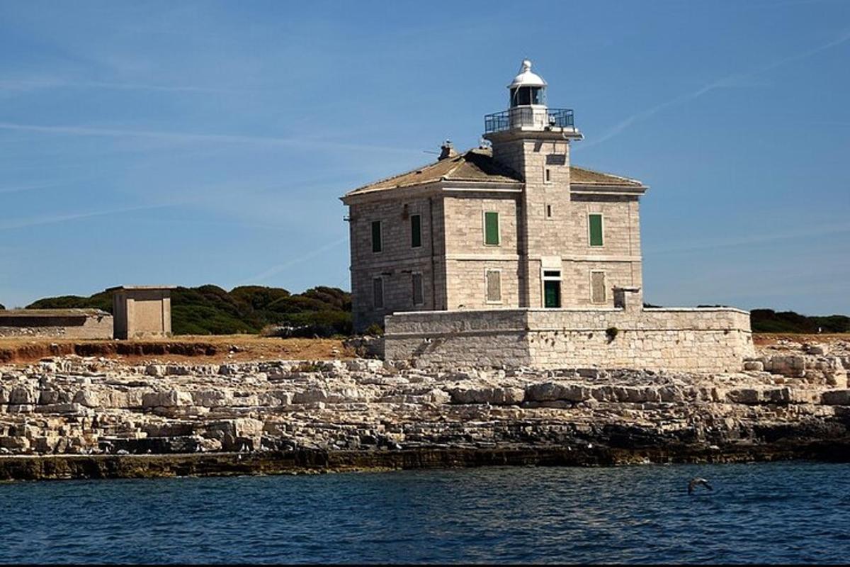 ein Leuchtturm auf einer Steinmauer neben dem Wasser
