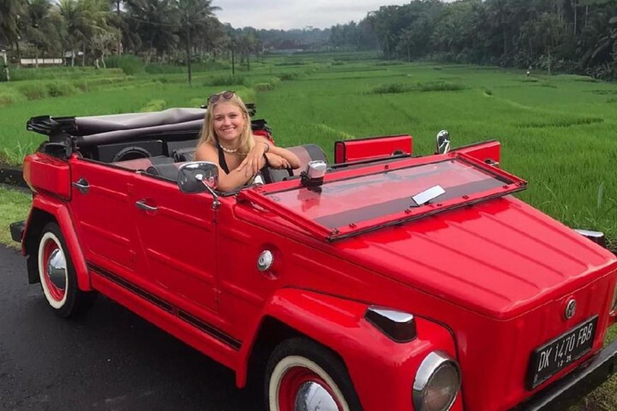 uma mulher está sentada em um carro conversível vermelho