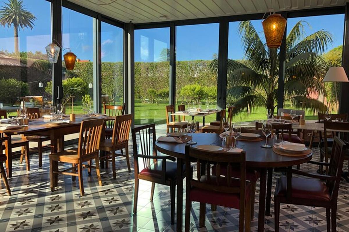 una sala da pranzo con tavoli, sedie e finestre