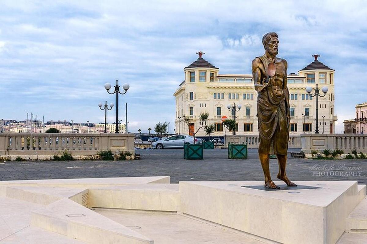 una estàtua d'un home dret sobre un pedestal davant d'un edifici