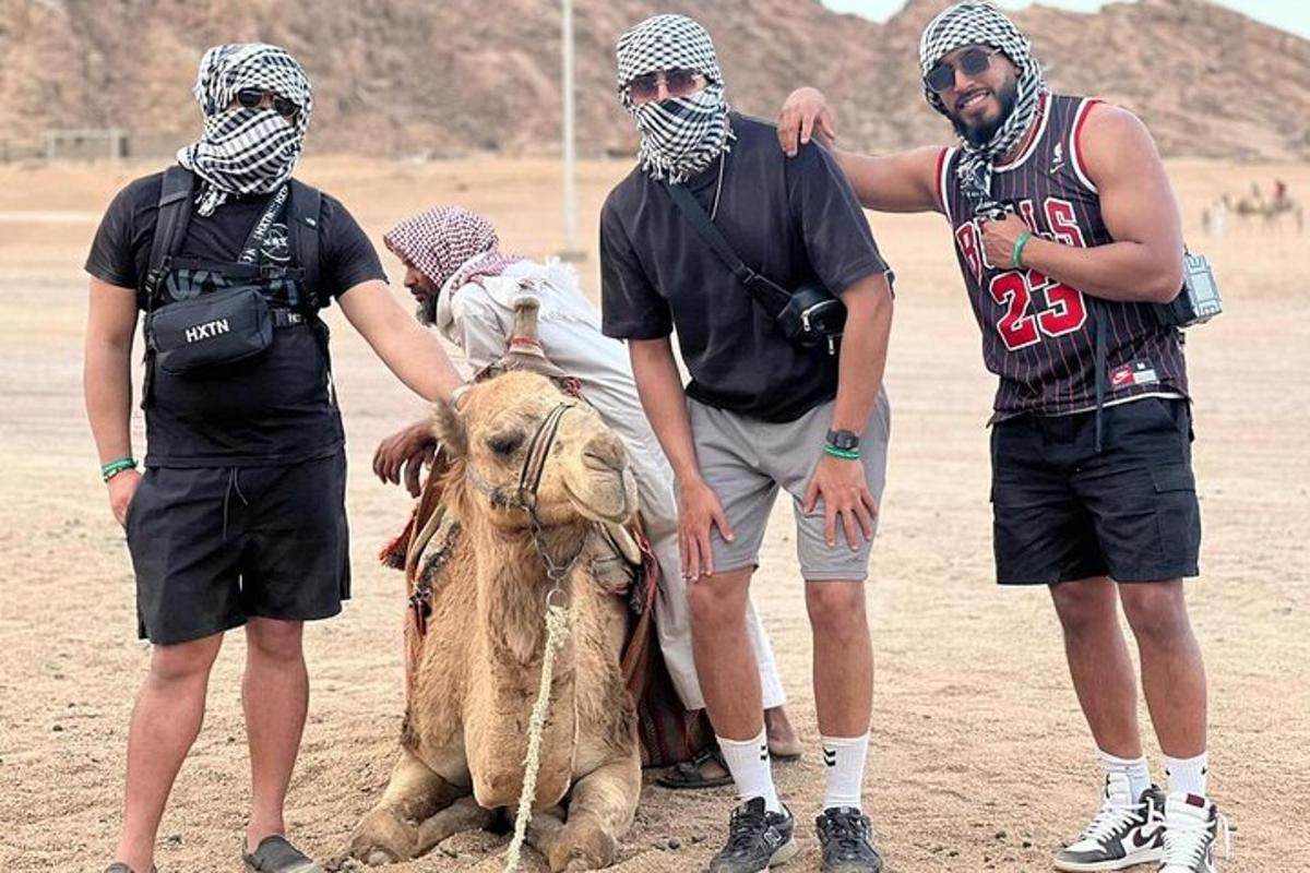 un gruppo di tre uomini in piedi accanto a un cammello