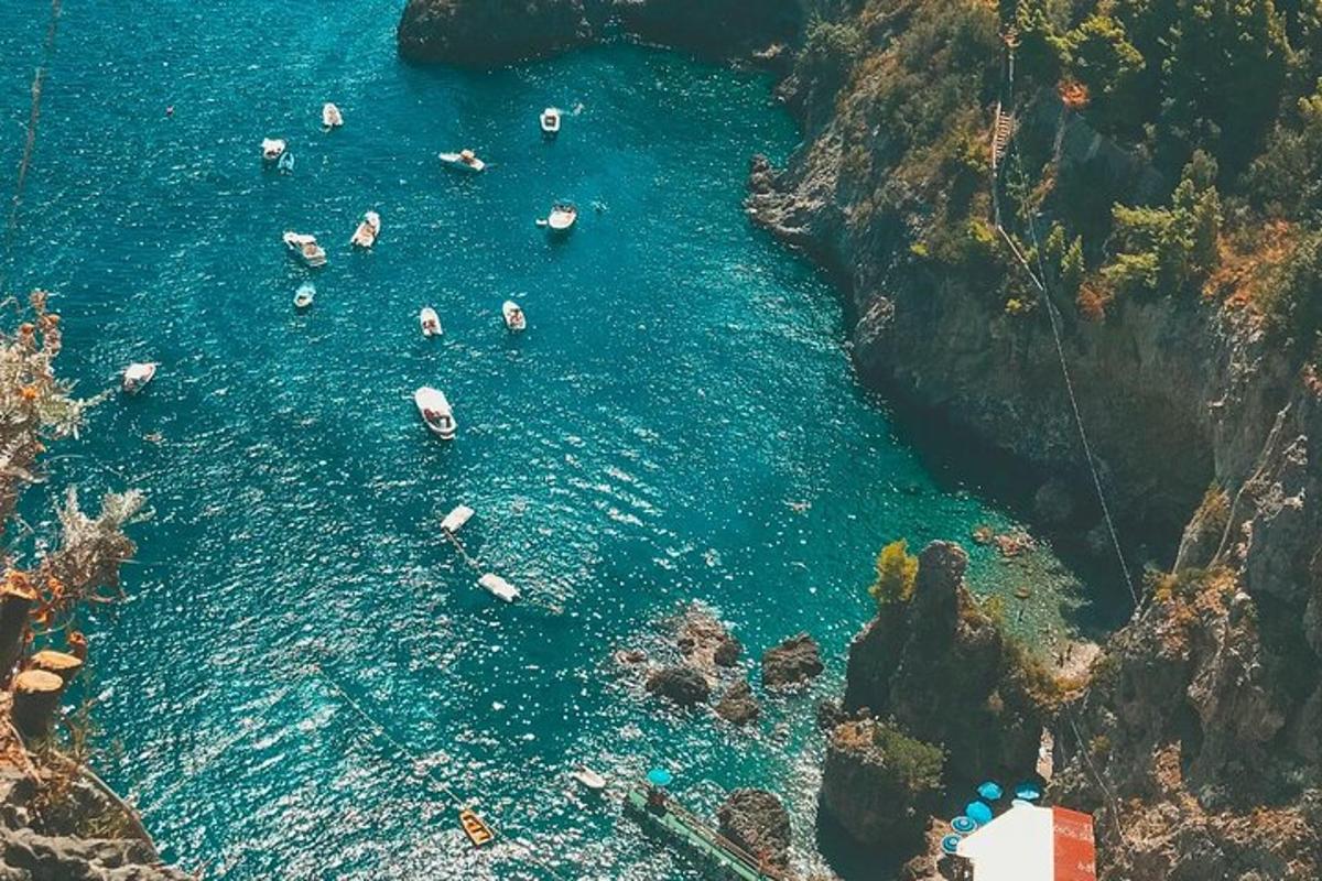Un grupo de personas en el agua cerca de un acantilado.