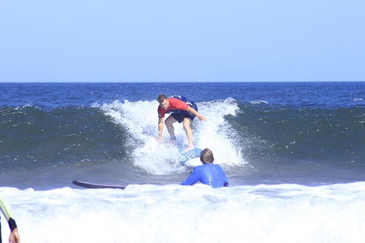 un bărbat călărind un val pe o placă de surf în ocean
