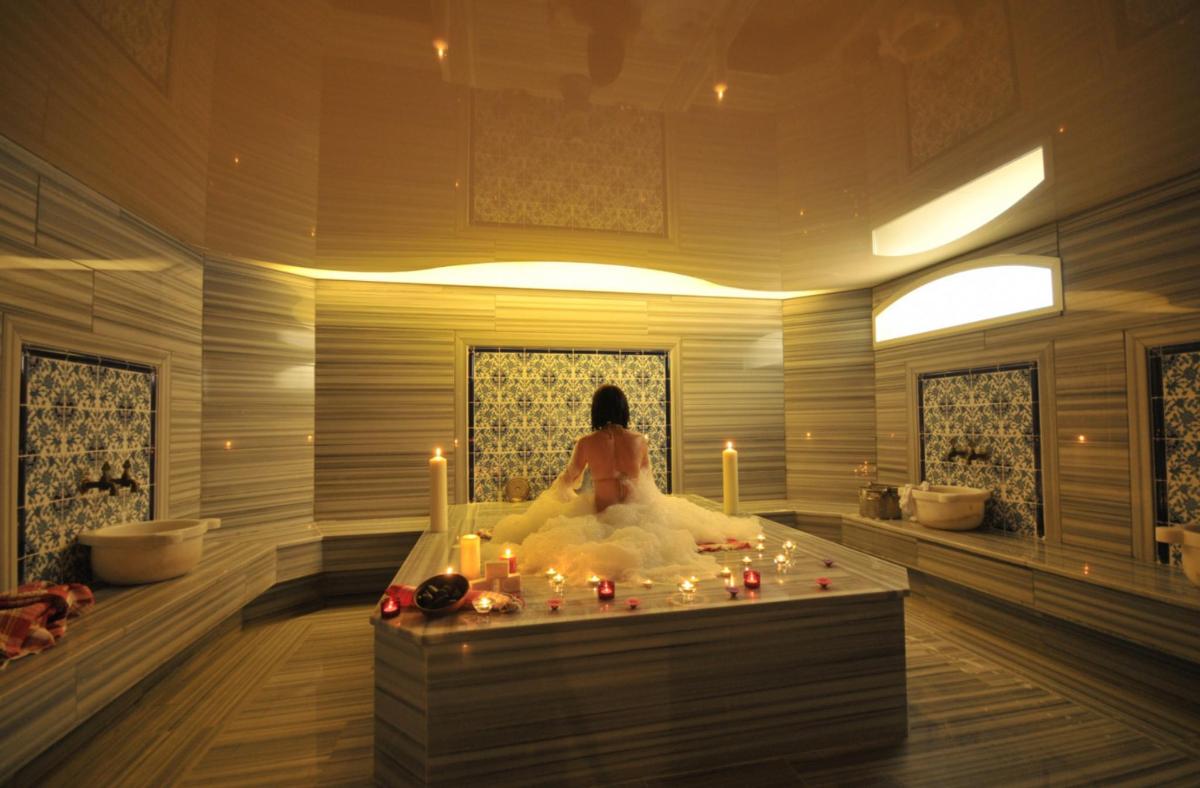 a woman sitting in a bath tub with candles