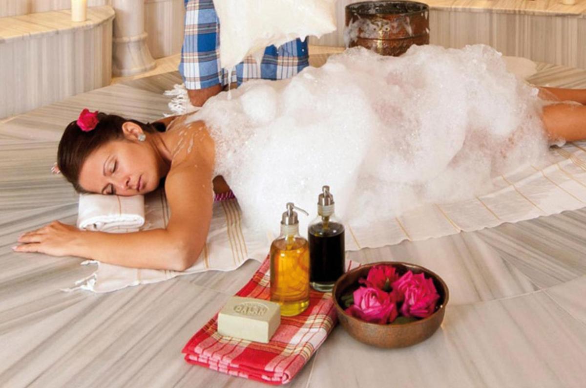 a woman laying on the floor with a bubble bath