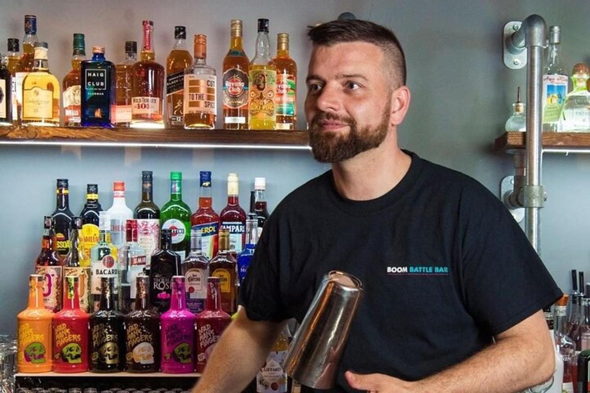 muž stojící před barem s lahvemi alkoholu