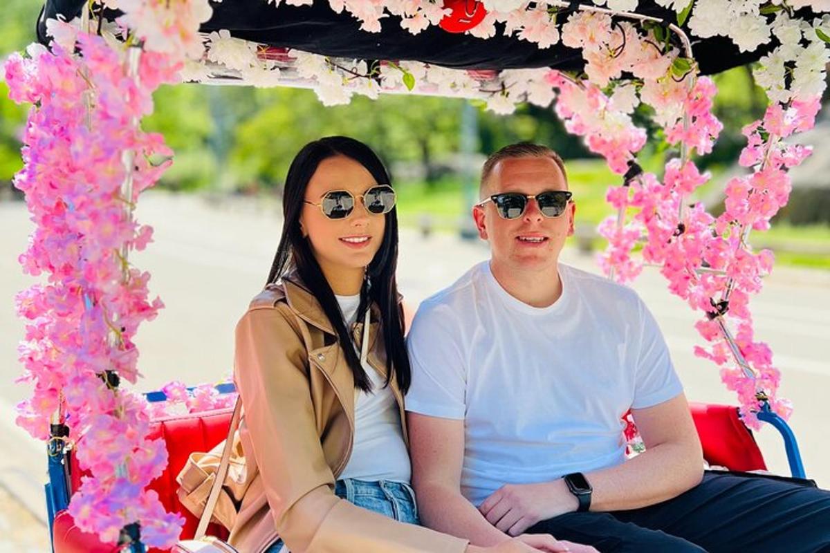 a man and a woman sitting on a cart with flowers