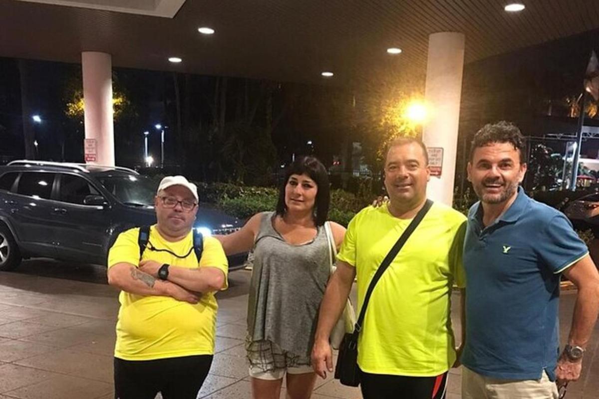 a group of people standing in front of a car