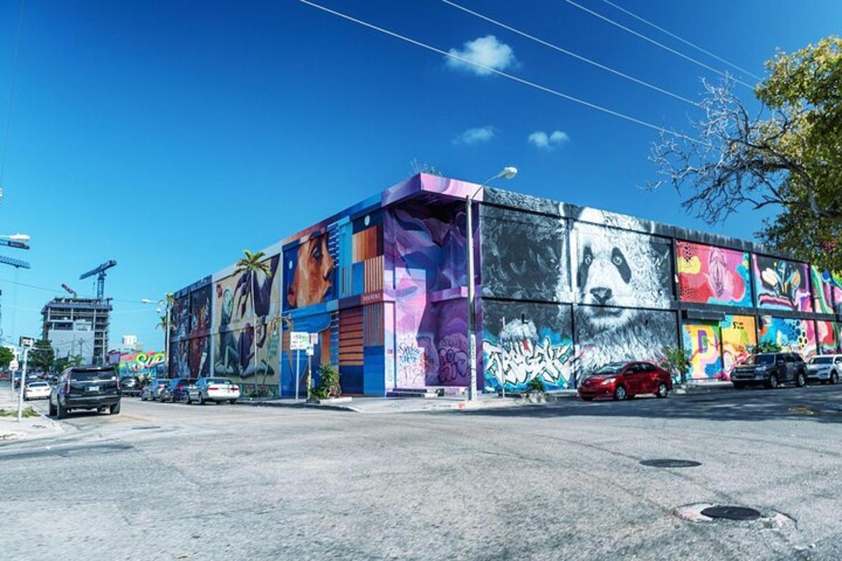 a building covered in graffiti with cars parked in front of it