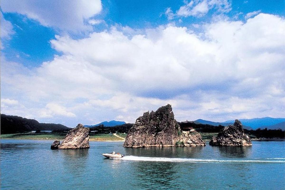un gruppo di rocce nell'acqua con una barca