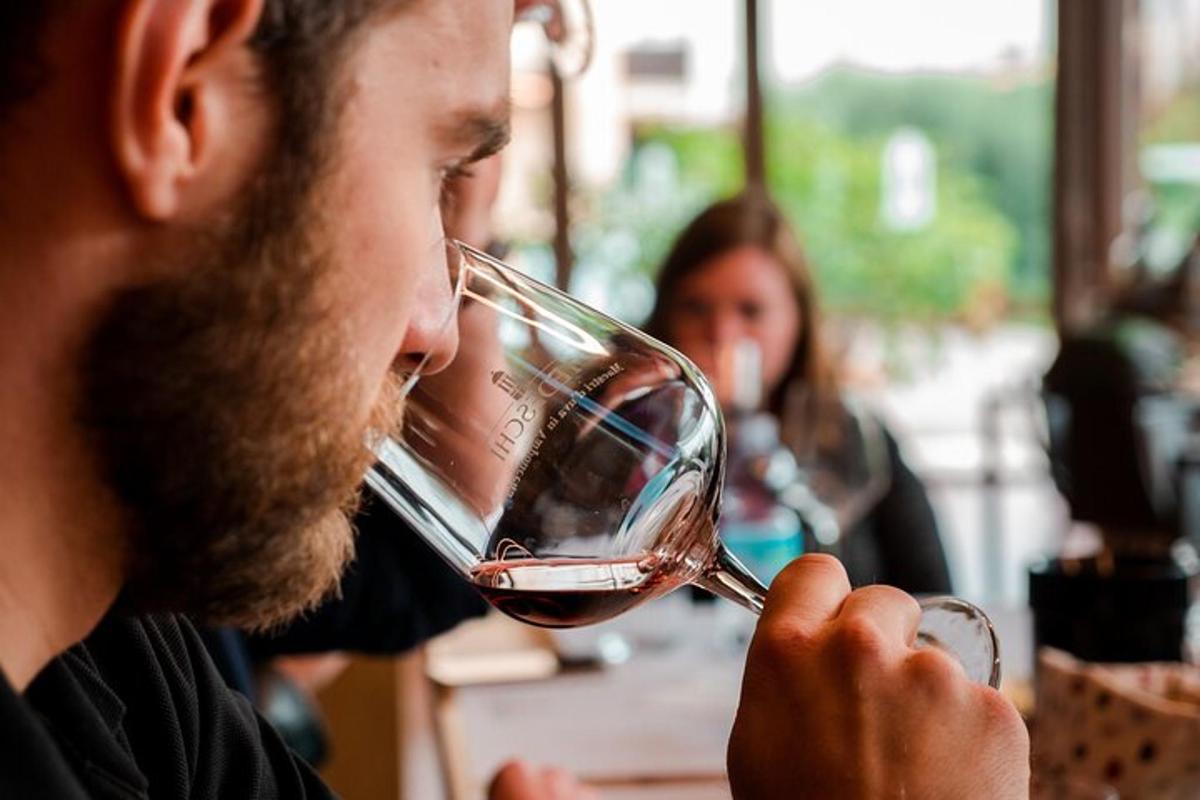 un uomo che beve un bicchiere di vino rosso