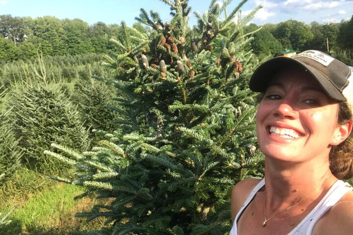 a woman standing in front of a christmas tree