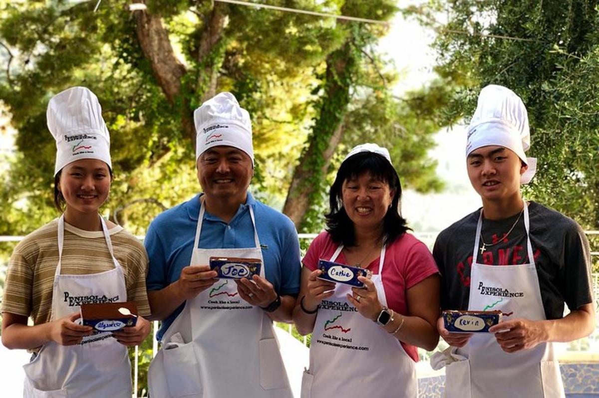 um grupo de quatro pessoas de avental segurando comida