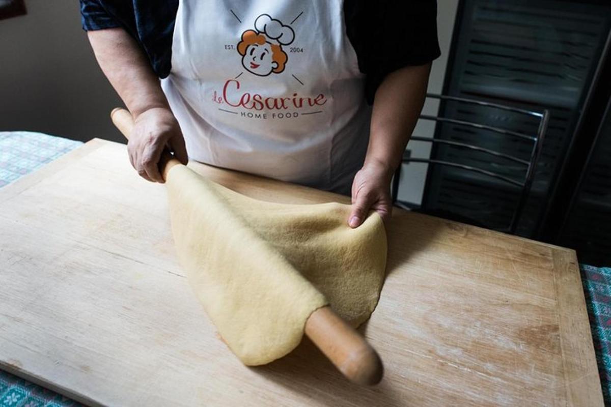 o persoană frământă o bucată de aluat pe un tocător