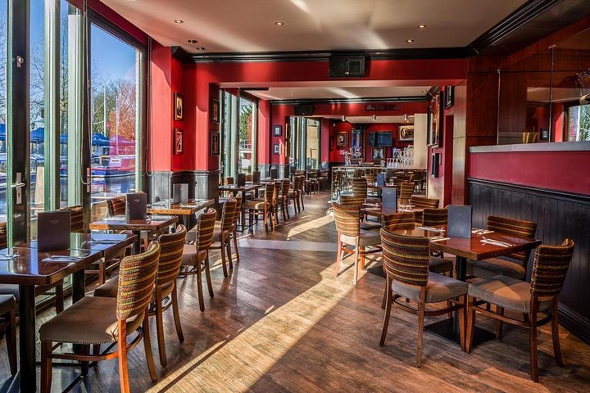 a restaurant with red walls and wooden tables and chairs