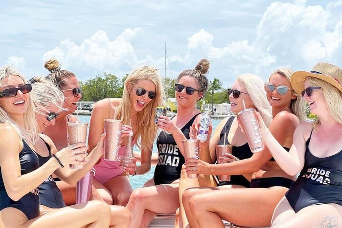sekumpulan wanita dalam pakaian mandi memegang minuman