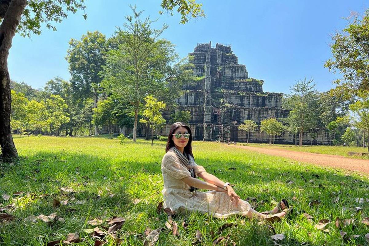 a woman sitting in the grass in front of a building
