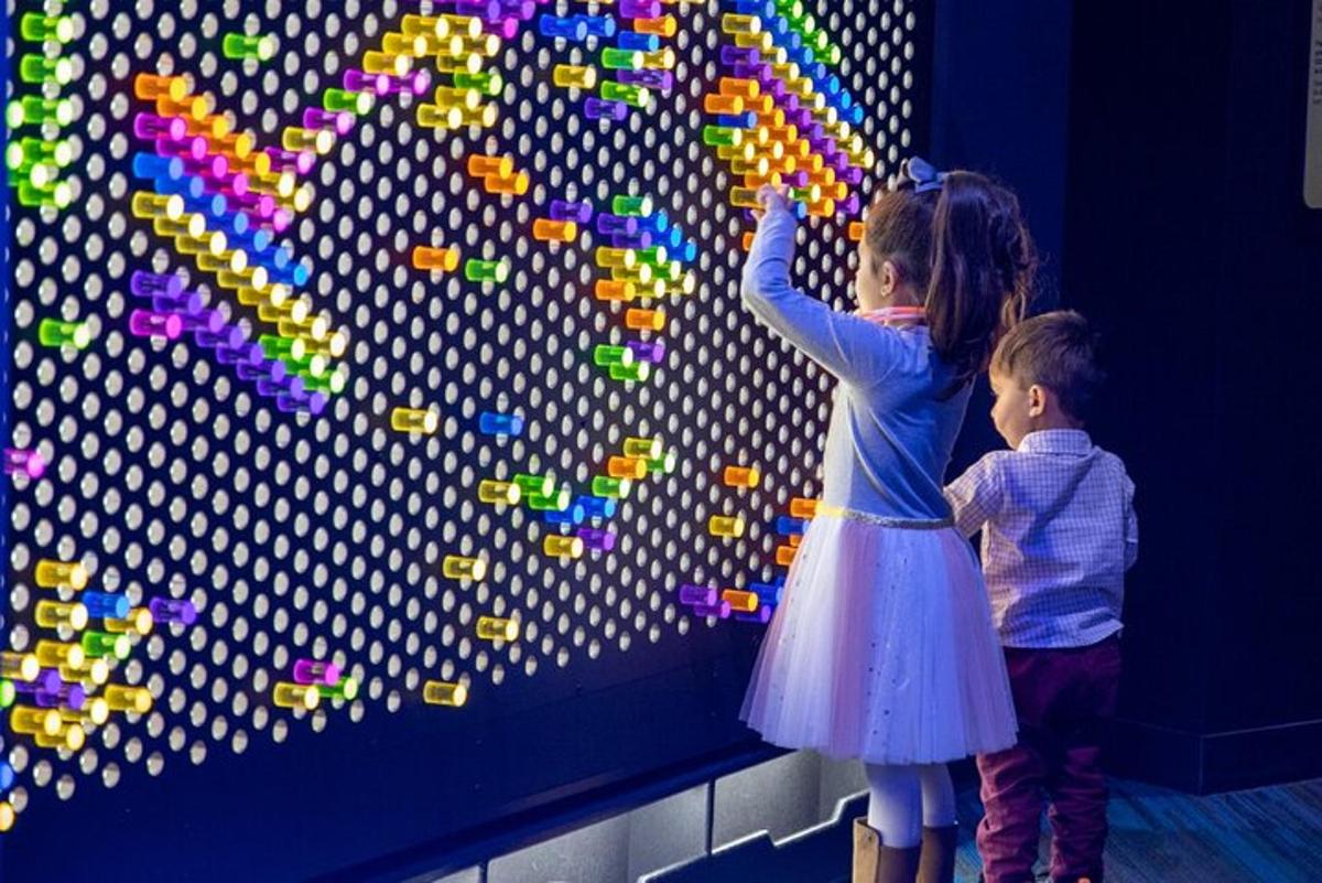 zwei Kinder spielen mit Buchstaben an einer Wand