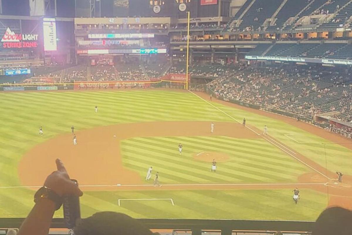 una persona tomando una fotografía de un partido de béisbol
