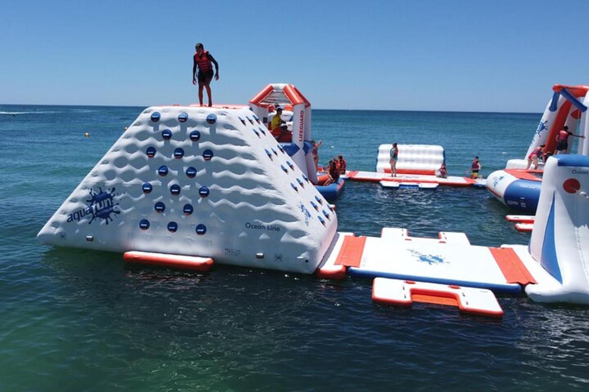 a man standing on top of an inflatable playground in the water