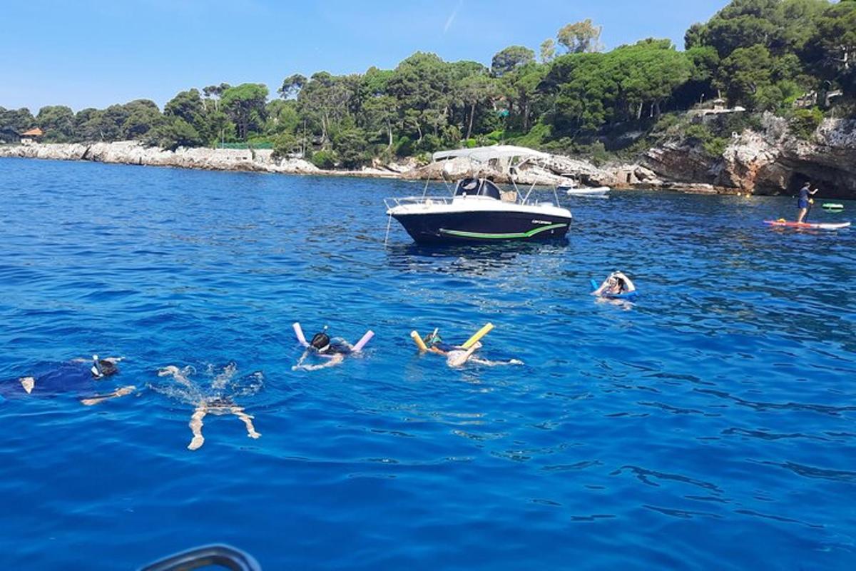 un gruppo di persone che nuotano nell'acqua vicino a una barca