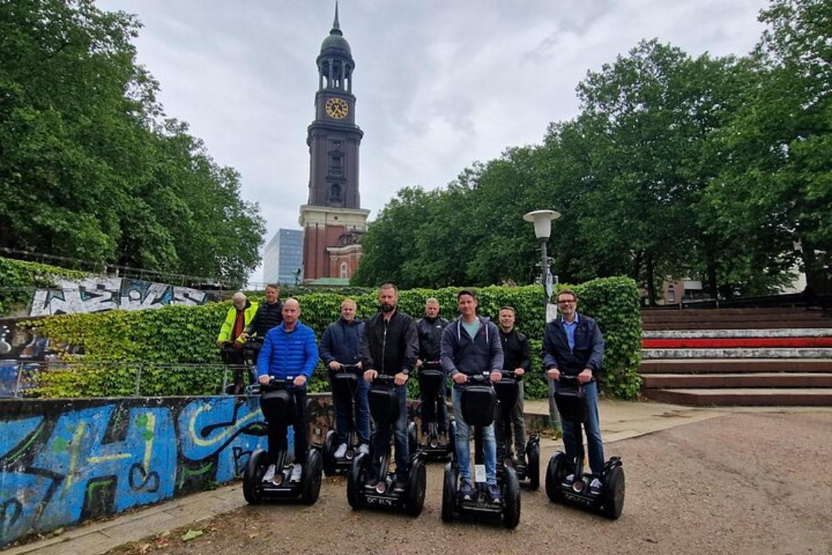 un gruppo di persone in segway davanti a una torre dell'orologio