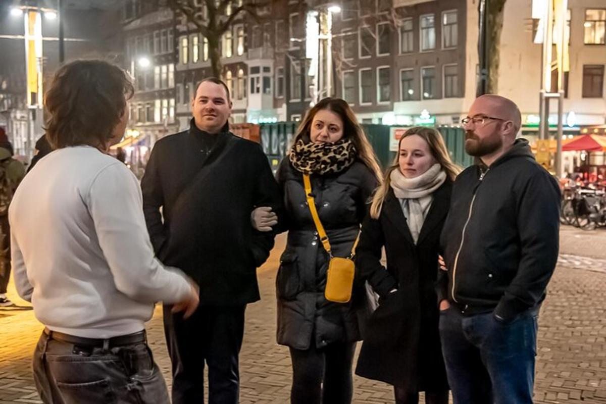 grupa ludzi stojąca na ulicy nocą