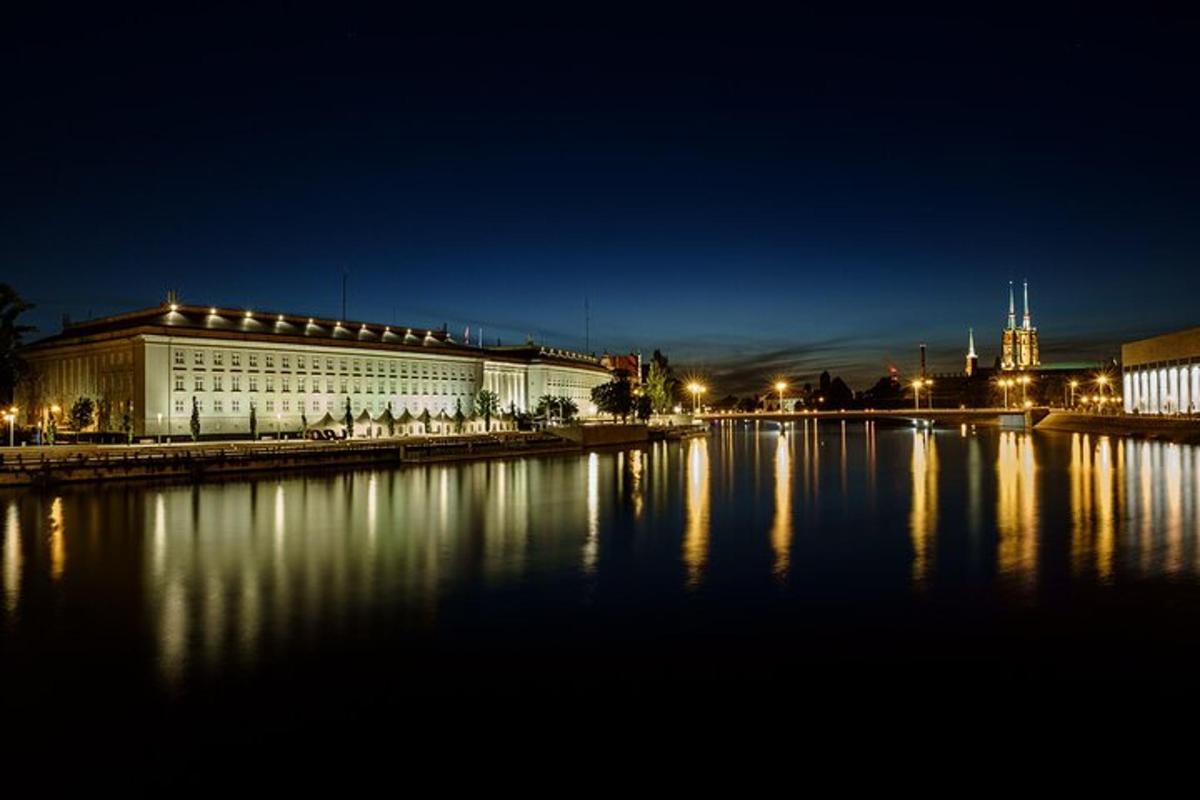a large building with lights on the water at night