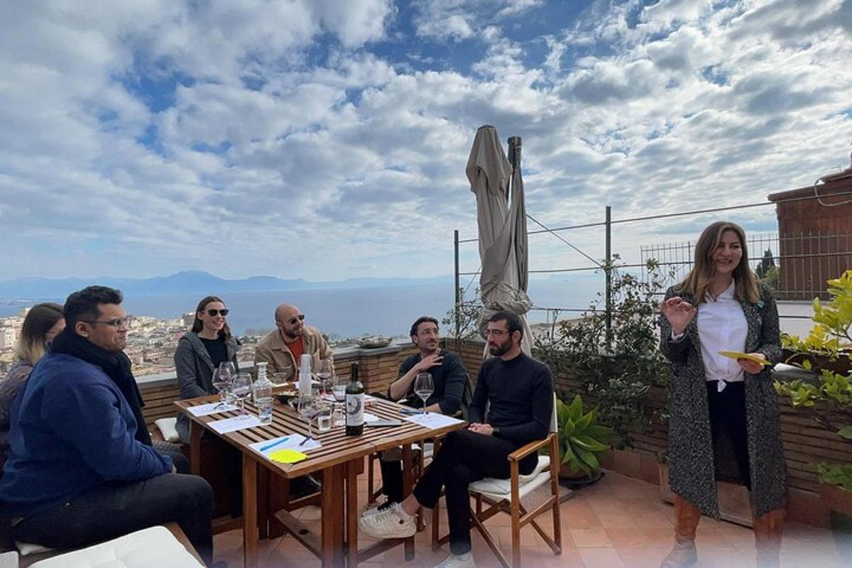 een groep mensen die rond een tafel op een terras zitten