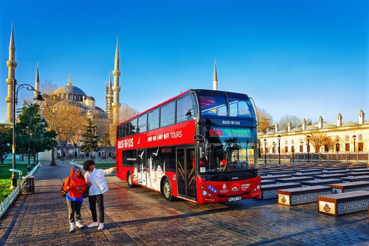 un autobus rosso a due piani davanti a una moschea