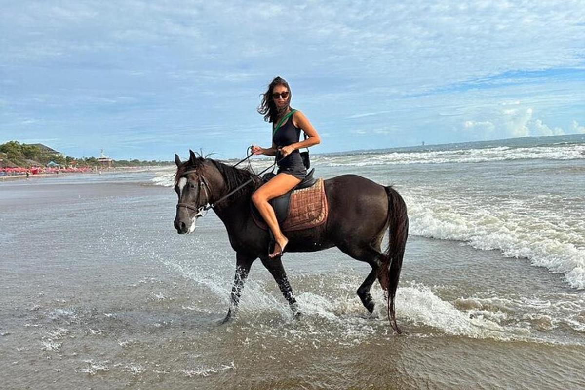 eine Frau, die am Strand reitet