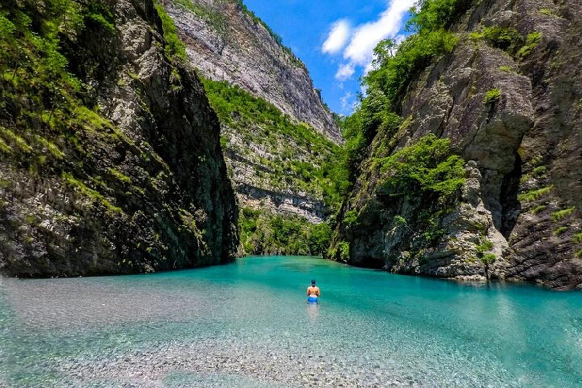 Ein Mann steht in einem Wasserbecken in einer Schlucht
