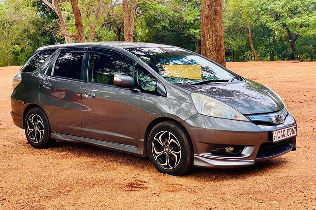 una piccola macchina argentata parcheggiata su un campo sterrato