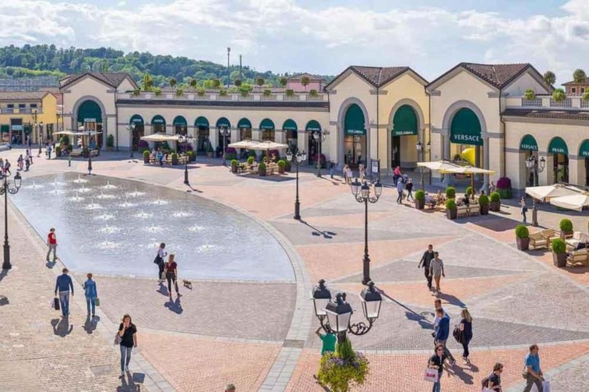 hópur fólks gengur um torg með gosbrunni