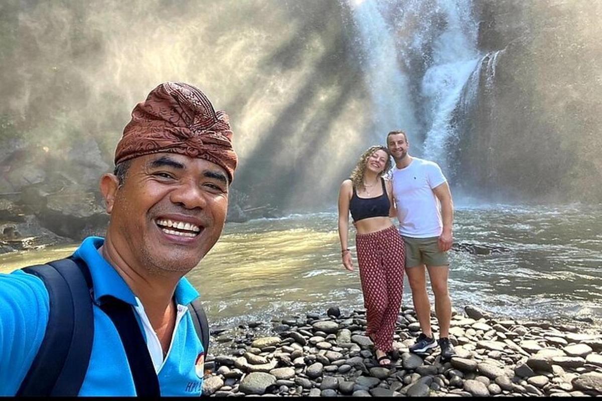 un uomo e una donna in piedi davanti a una cascata