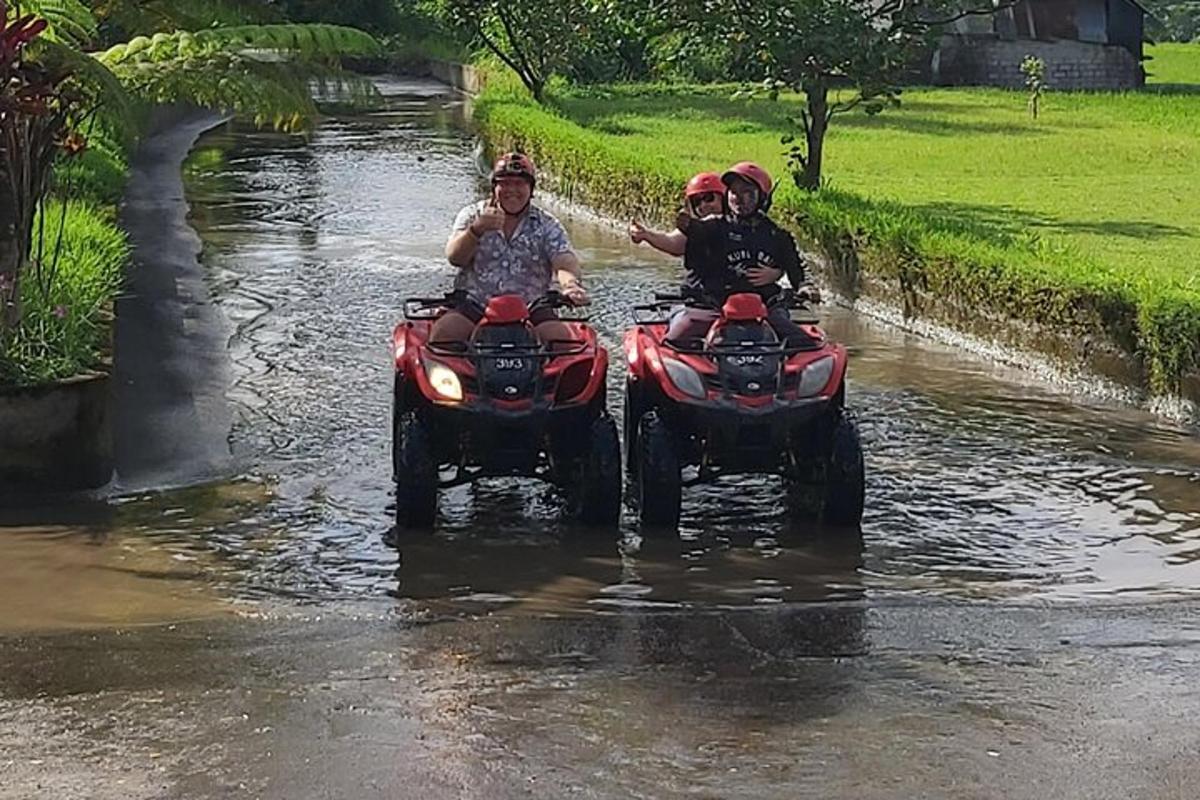 dalawang tao na nakasakay sa mga atv sa isang ilog