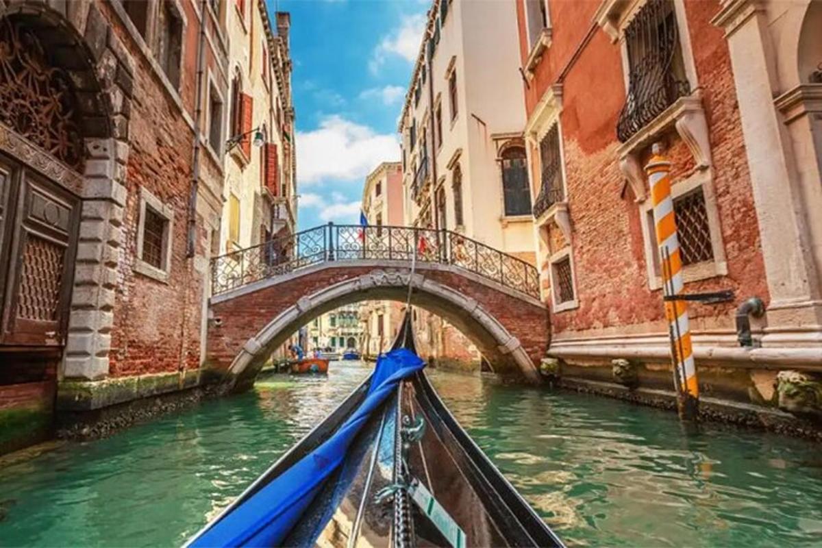 una gondola che rema attraverso un canale con un ponte