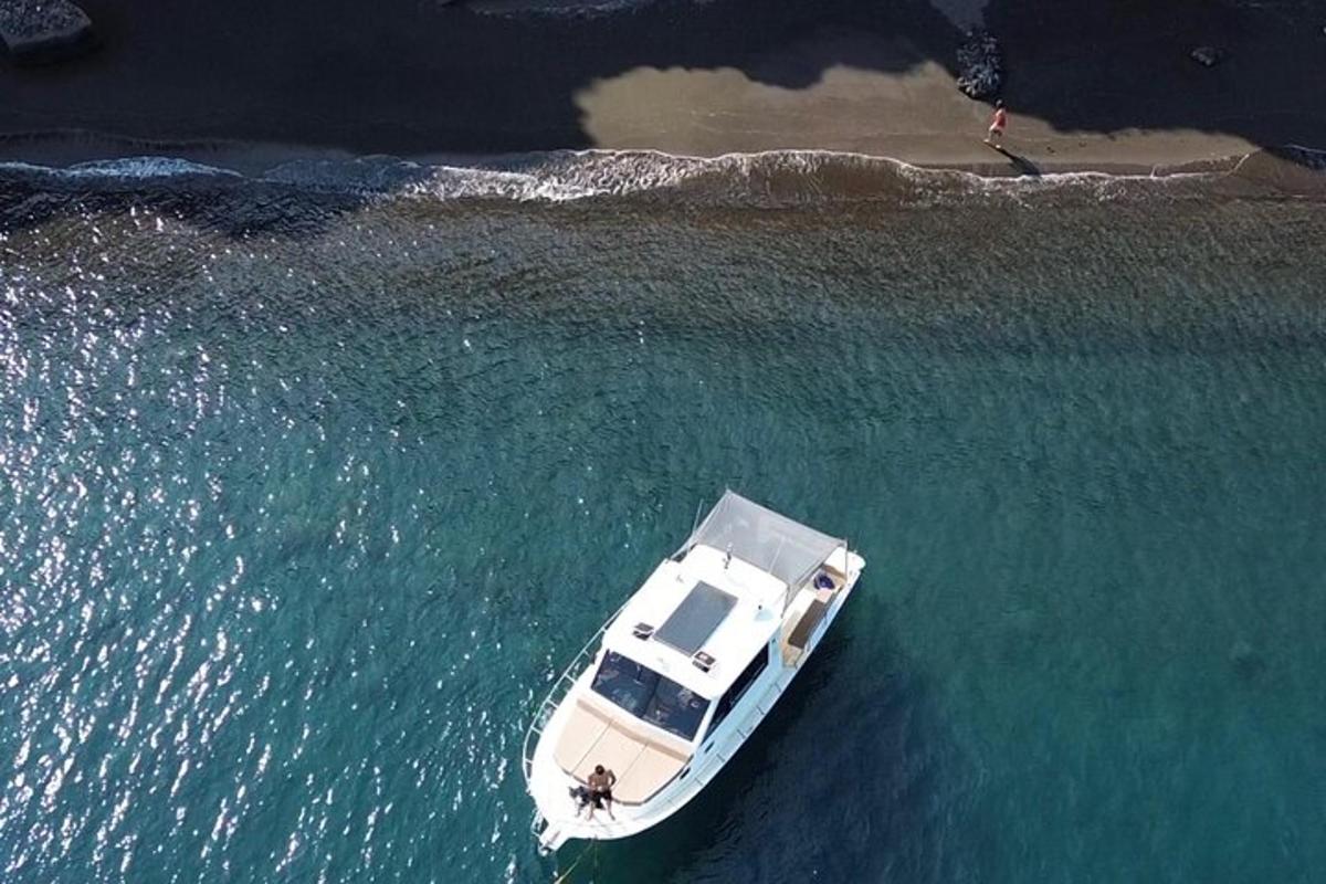 una barca bianca nell'acqua accanto a una spiaggia