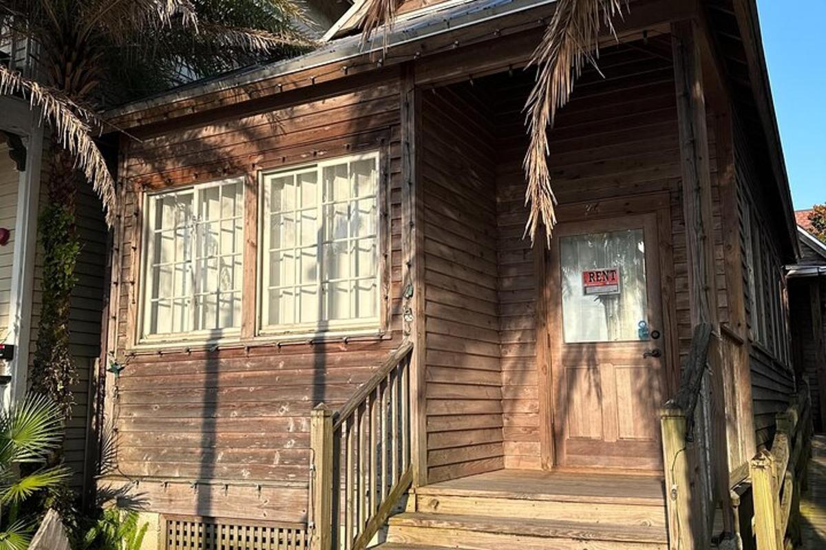 una casa di legno con una porta e un cartello sopra