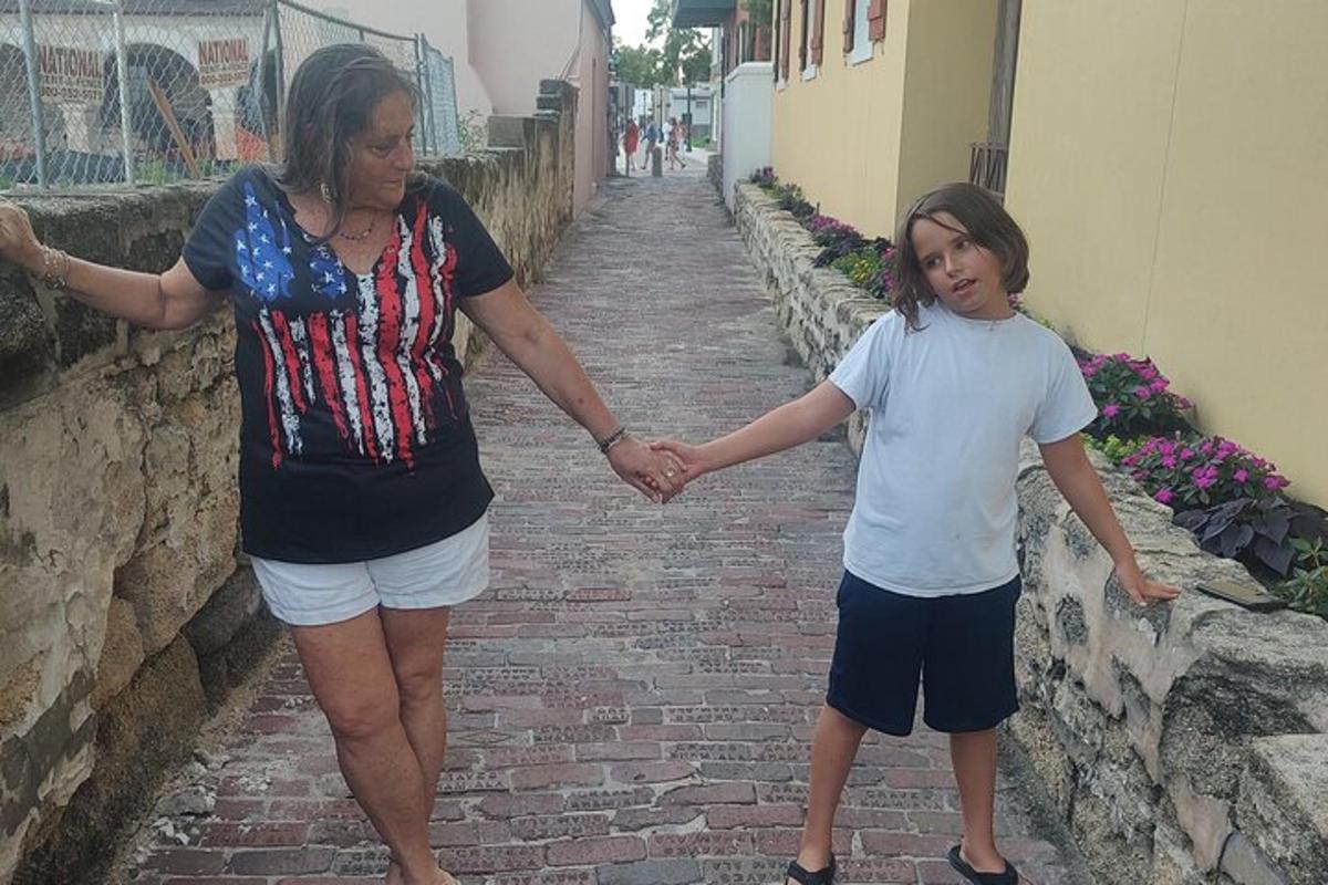 una donna e un bambino che si tengono per mano mentre camminano lungo una strada